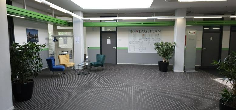 Spacious reception area at Kleve's Tech Hub, 16 Boschstraße, Business District featuring colorful seating and plants.
