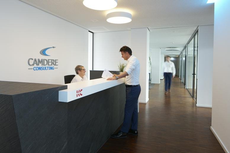 Bright, modern reception area at Mörikestraße 19, Stadtmitte, Ulm with a dark stone front desk.