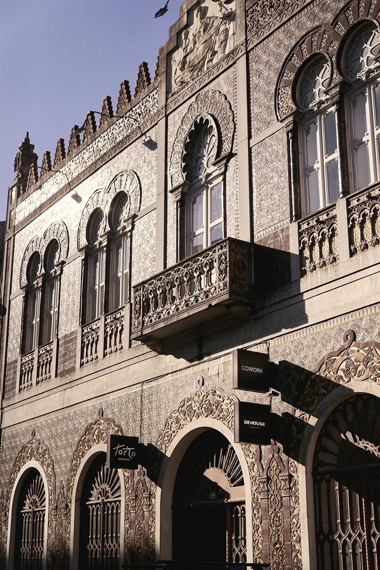 Detailed view of the ornate tiled facade and arched windows of the Arabic Building.