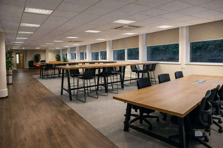 Spacious open-plan workspace at 27 Derby Street, Town Centre with long wooden tables and black stools.
