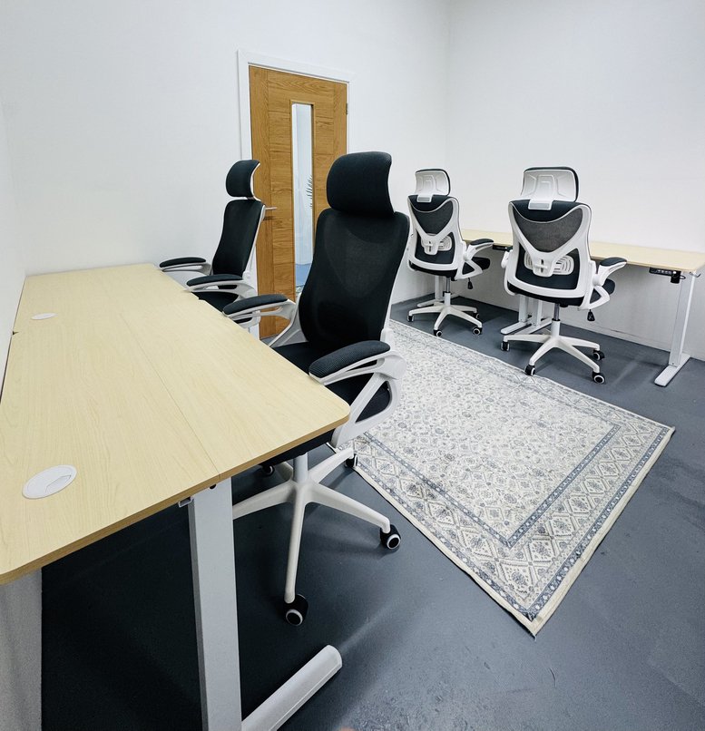A well-lit private office space at 29-39 London Road featuring light wood desks and ergonomic black chairs.