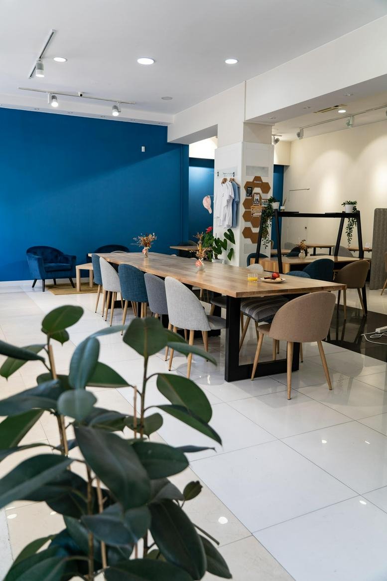 Spacious communal coworking area at 3, Calle de Fernández de los Ríos, Madrid with a long wooden table and blue wall.
