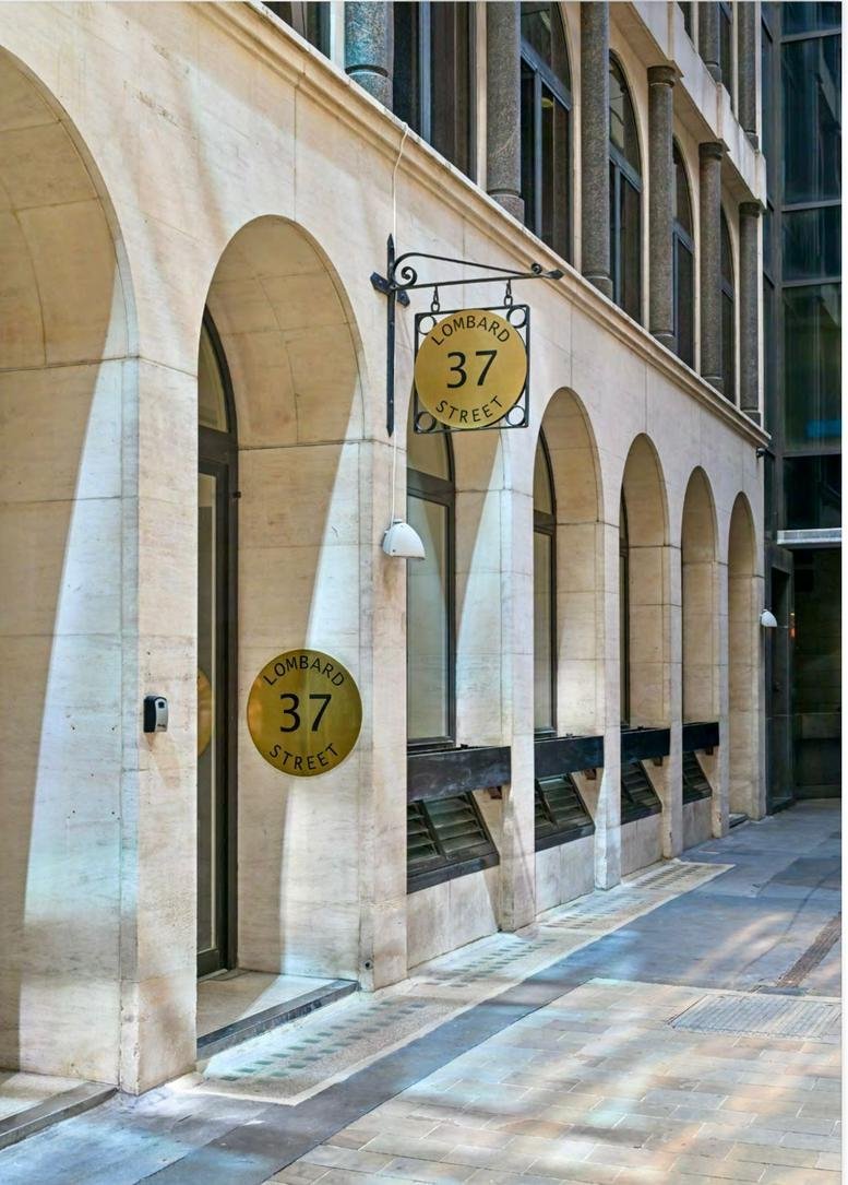 Exterior view of the arched stone facade and entrance at 37 Lombard Street.