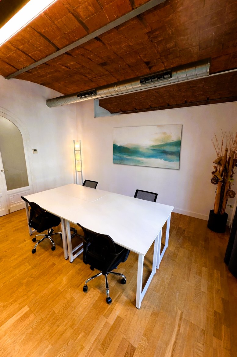 Professional meeting room at 449 Avinguda Diagonal, Barcelona featuring white desks and a vaulted brick ceiling.