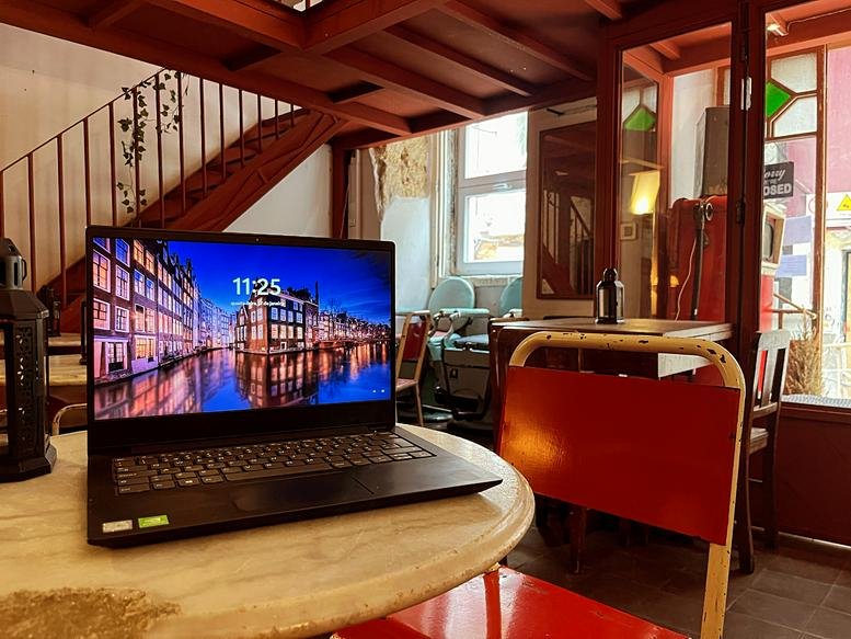 Laptop on a marble table in the warm communal lounge at Alface Hall, 96 Rua do Norte, Bairro Alto, Lisbon, Portugal.