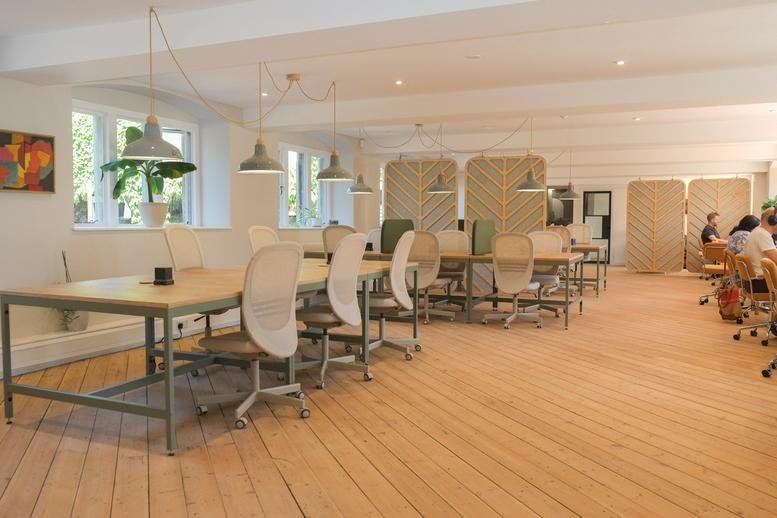 Spacious open-plan workspace at Kilver Court featuring wooden floors and industrial pendant lighting.