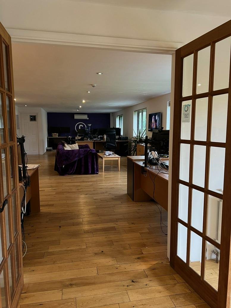 Spacious open-plan interior of The Workshop, Old Barn Cottage, featuring wooden floors and a purple lounge area.