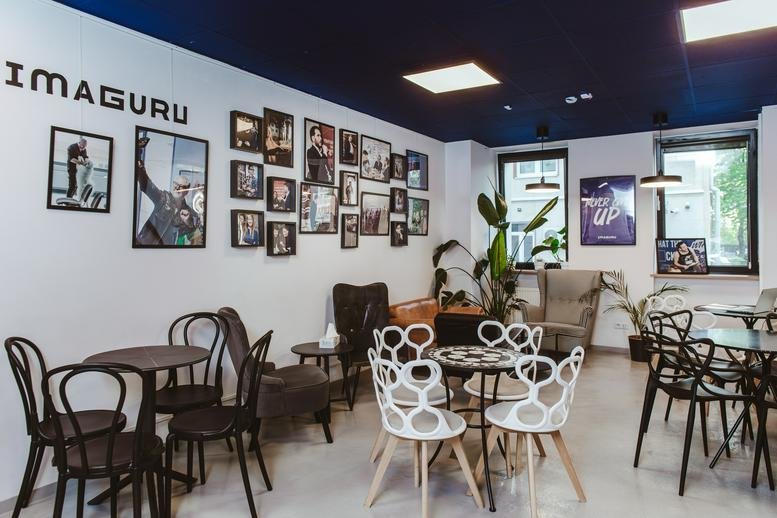 Vibrant communal cafe area at Twarda 14/16 featuring eclectic seating and a gallery wall.