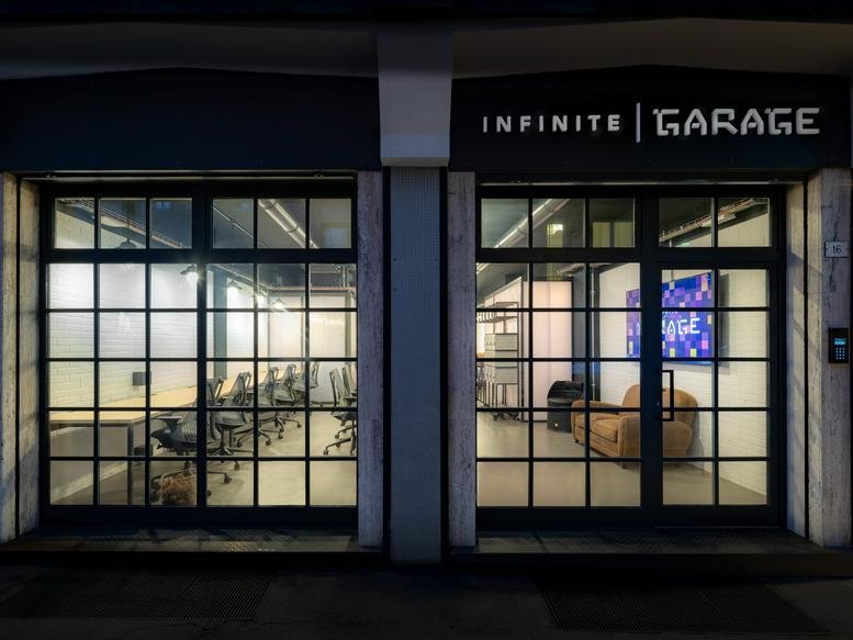 Ground floor exterior facade of Infinite Garage at Via delle Absidi 16, Treviso, with large gridded windows.