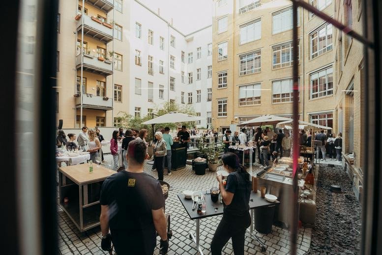 Central courtyard of Zionskirchstraße 73a filled with people during an outdoor event.