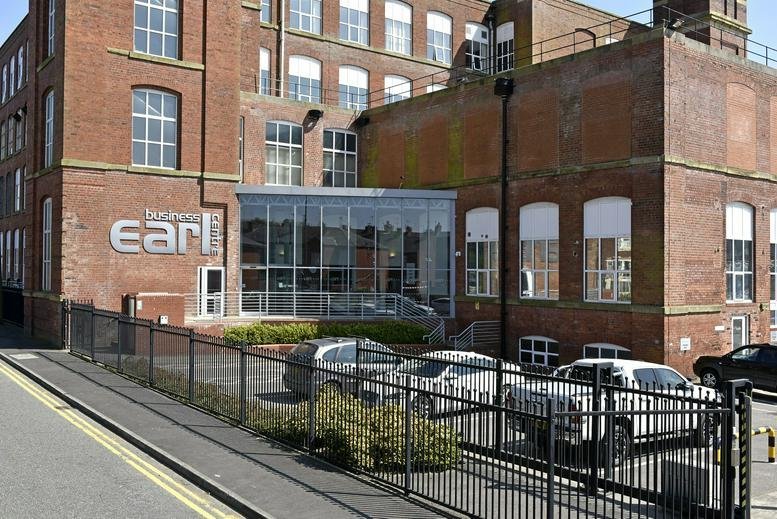 Red brick exterior view of Earl Business Centre, Dowry Street with a modern glass entrance and parking area.
