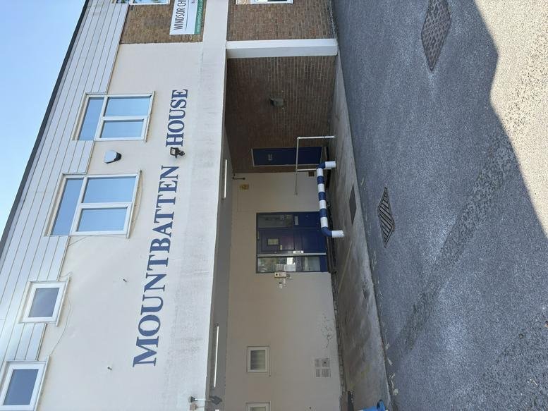 Exterior view of the white facade and entrance of Mountbatten House at Fairacres Industrial Estate.