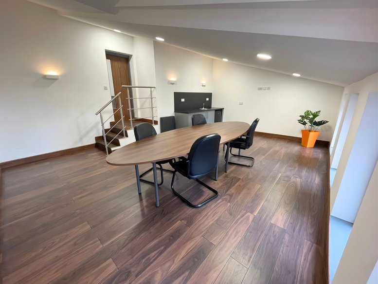 Spacious meeting room at Gibbons Industrial Park, Unit 10 Dudley Road with oval table and wood flooring.
