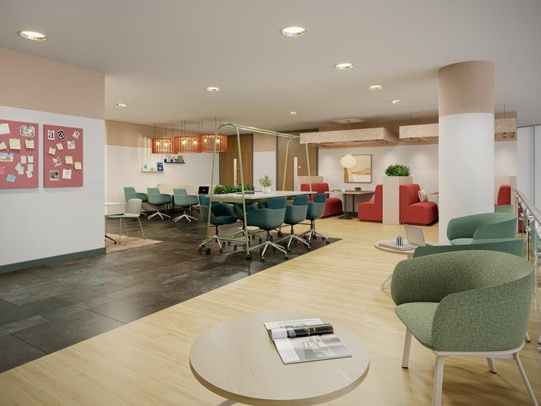 Spacious, modern communal lounge at Godwin Street with teal armchairs, long tables, and vibrant red seating pods.