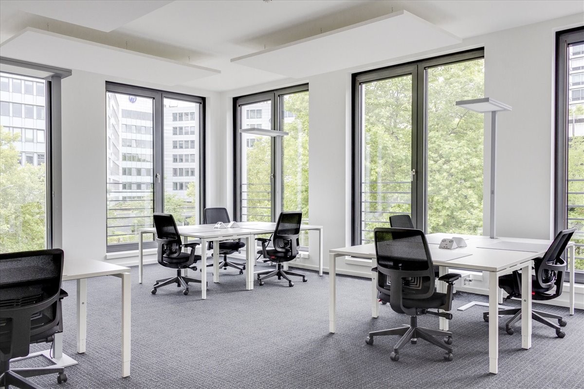 Bright open-plan office space at Groat House, 20 Collingwood Street with white desks and large windows.