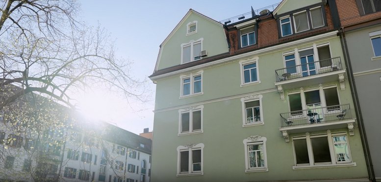 Exterior view of the light green residential and commercial building at Hohlstrasse 216.
