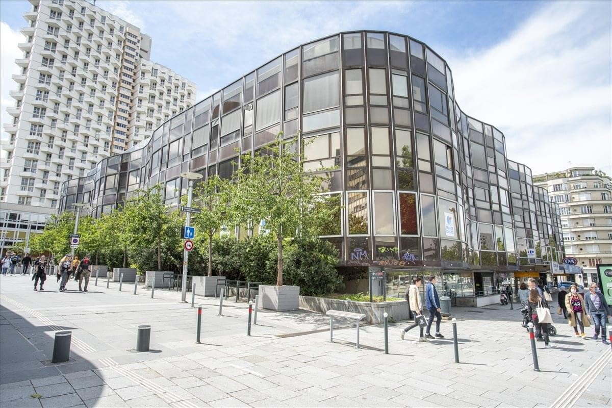 Exterior view of the curved glass facade of the Immeuble 3 Soleils building.