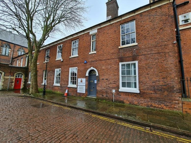 Red brick exterior of Kings House, St Johns Square with arched doorway and white-framed windows.