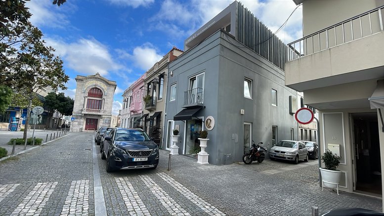 Street view of the grey building at Largo Fonseca Lima, n. º 11, 2º Andar under a blue sky.