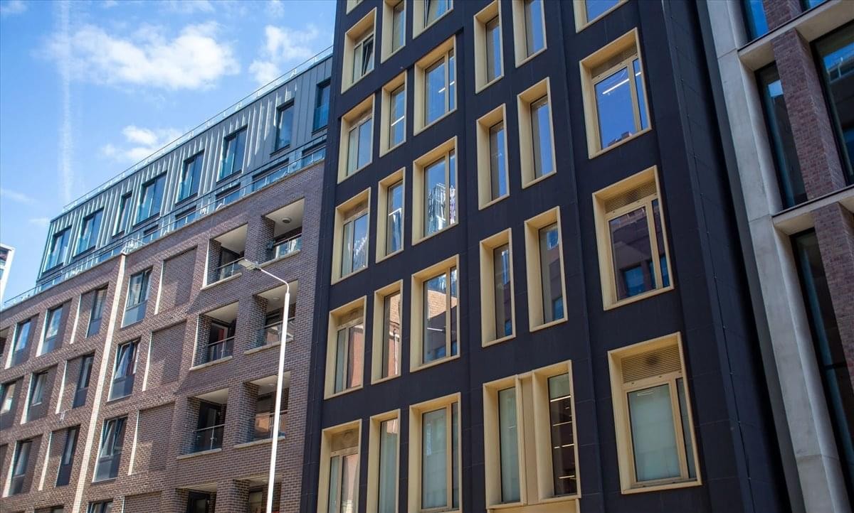 Exterior view of the modern dark-paneled facade at 10 Alie Street, London.