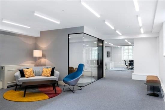 Modern reception lounge at 20 Grosvenor Place with a grey sofa and a bright blue accent chair.