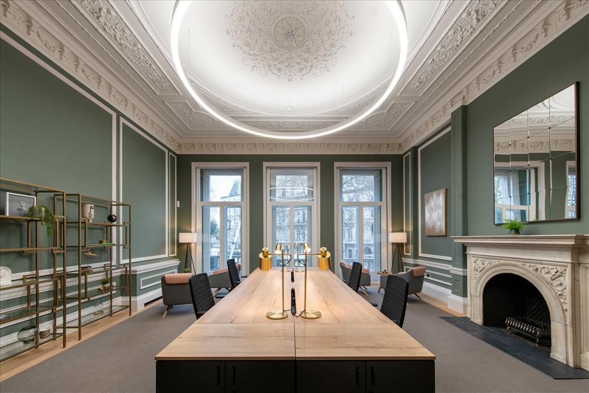 Grand shared workspace at 22 Grosvenor Gardens with ornate ceilings, green walls, and a large circular light.