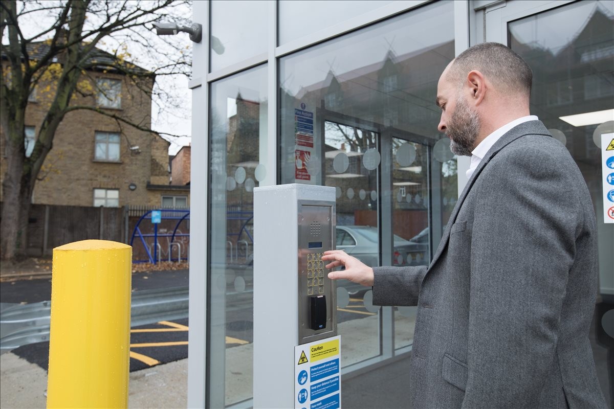 Man using the secure keypad entrance at 3 Stanton Way, Sydenham, London.