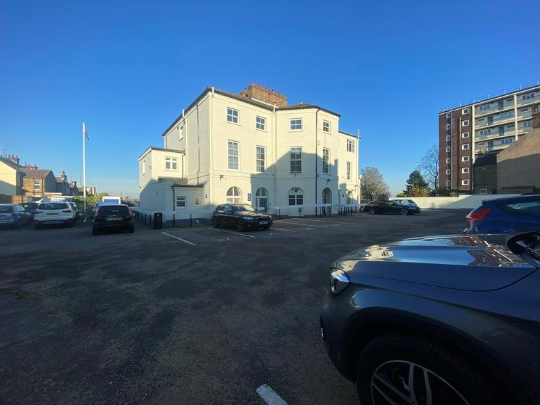 Exterior view of the white period building at 47 The Terrace showing the car park and facade.