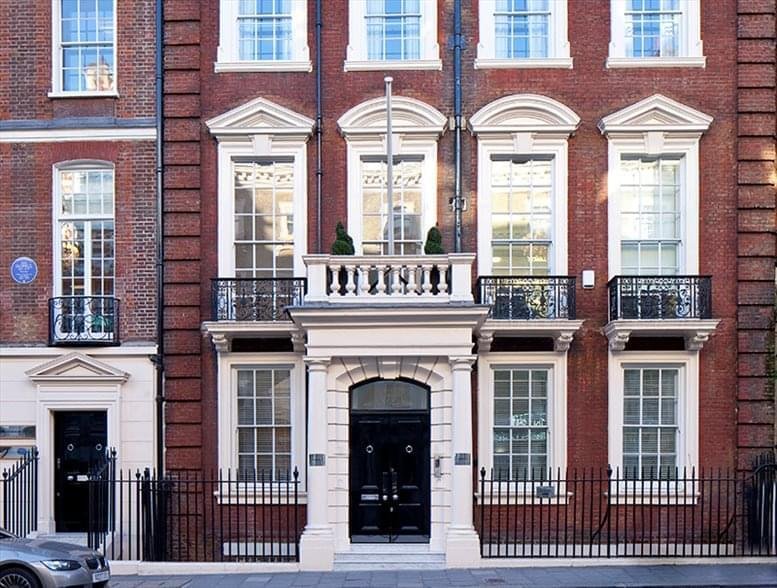 Red brick exterior of 59 Grosvenor Street, Mayfair featuring a classic grand entrance and sash windows.