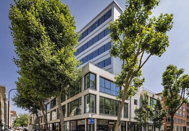 Modern white exterior of 60 Charlotte Street with large windows and green trees.