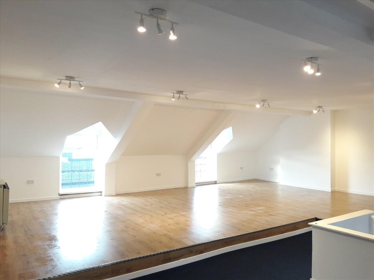 Spacious top-floor office suite at 63 Charles Street, Milford Haven with skylights and wooden flooring.