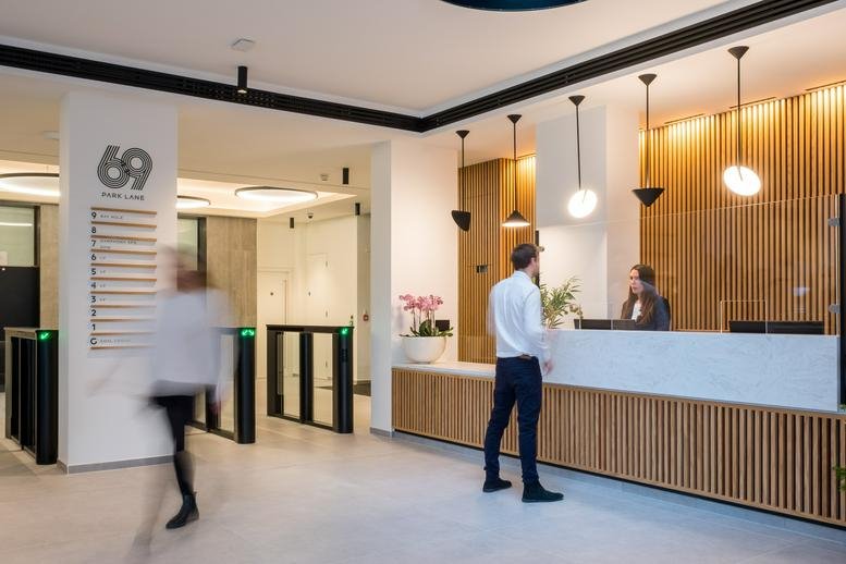 Modern lobby and reception area at 69 Park Lane featuring wooden paneling and pendant lighting.