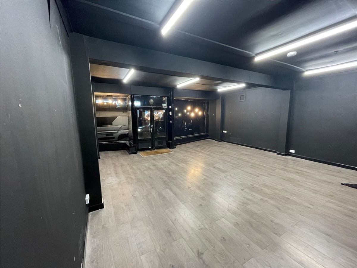 Spacious open-plan interior at 74B Exeter Road, Exmouth, Devon with dark walls and wood-style flooring.