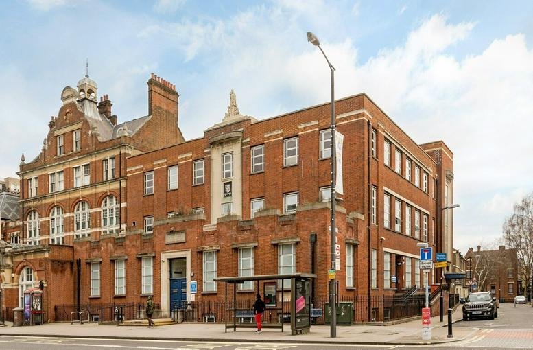 Exterior view of the historic red brick facade of Larcom House with large windows.