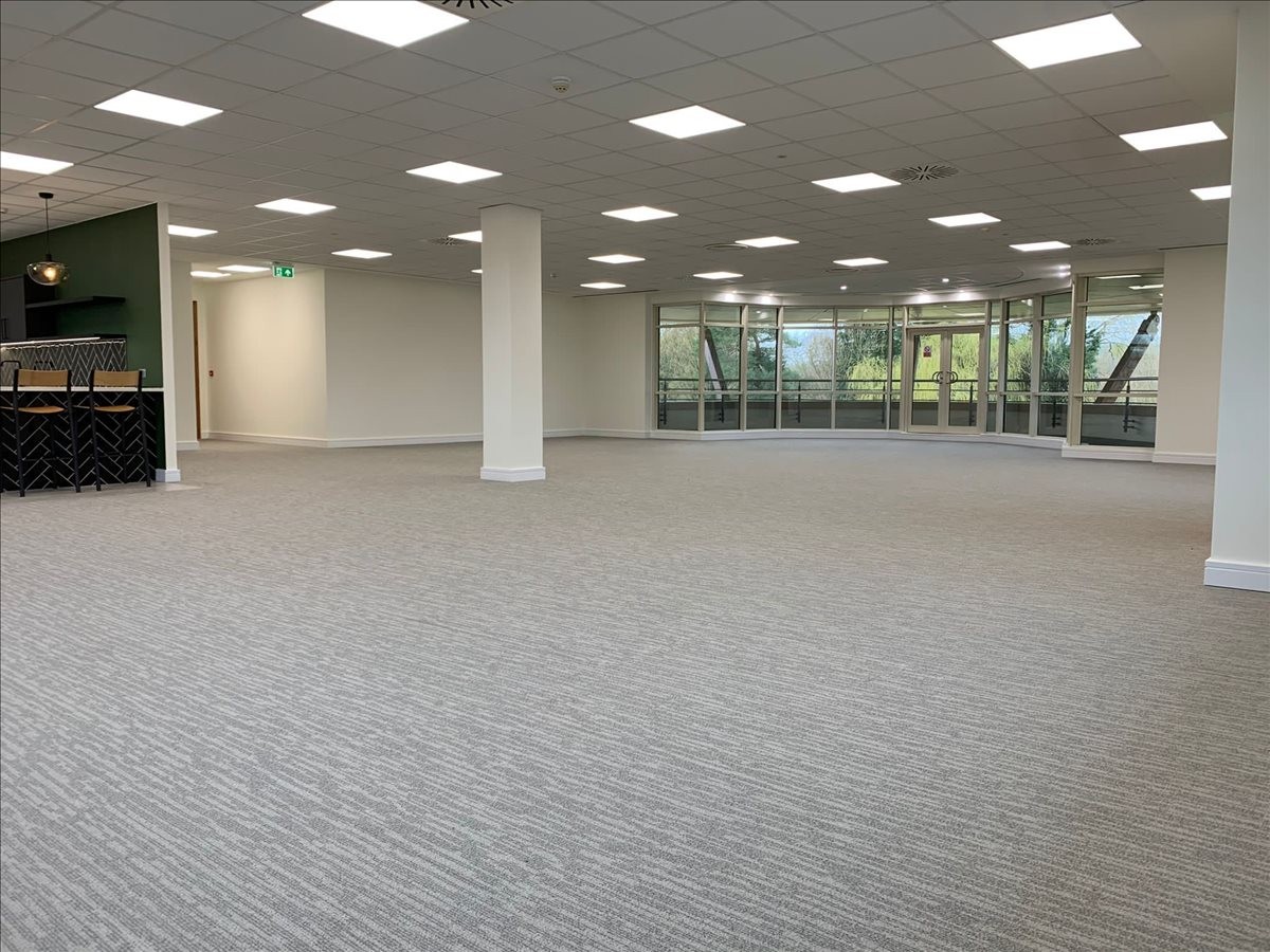 Spacious, open-plan floor at Bramley House, Guildford, Surrey with bright recessed lighting and large windows.
