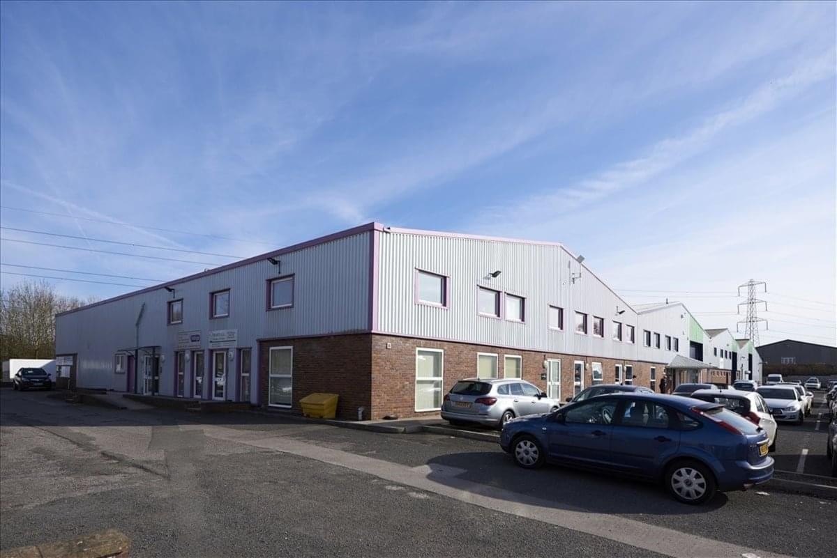 Exterior view of the Bromfield Commercial Park industrial unit showing the brick and metal facade under a blue sky.