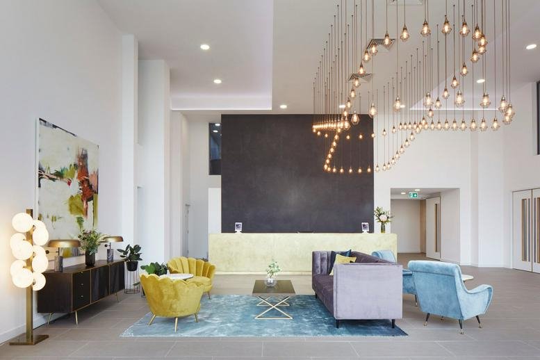 Bright reception area at Crown House with a large black feature wall and a unique light installation.