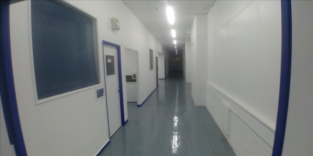 Long bright hallway with blue door frames at Egyptian Mill, Egyptian Street, Bolton.