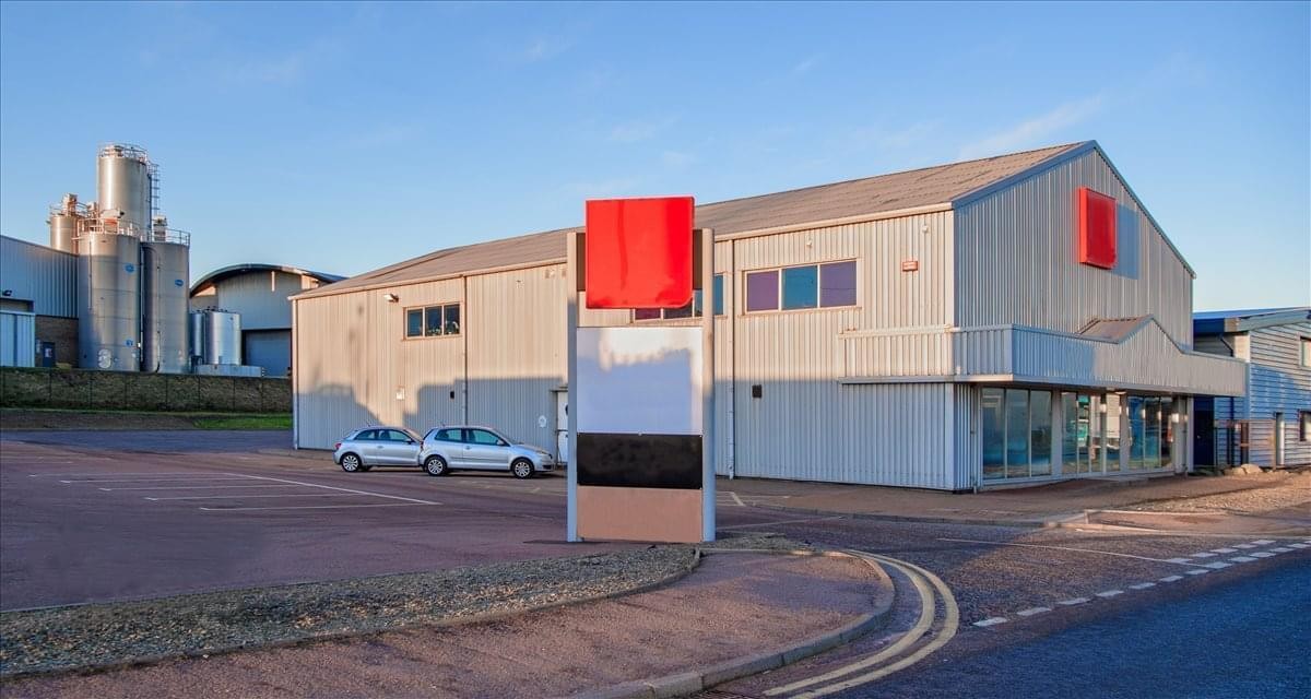 Industrial-style exterior of Graphic House with a red and white sign board and parking area.