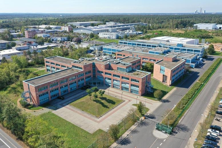 Aerial view of the red brick and blue accented business park at Industriestraße 13, Hanau, Hesse.