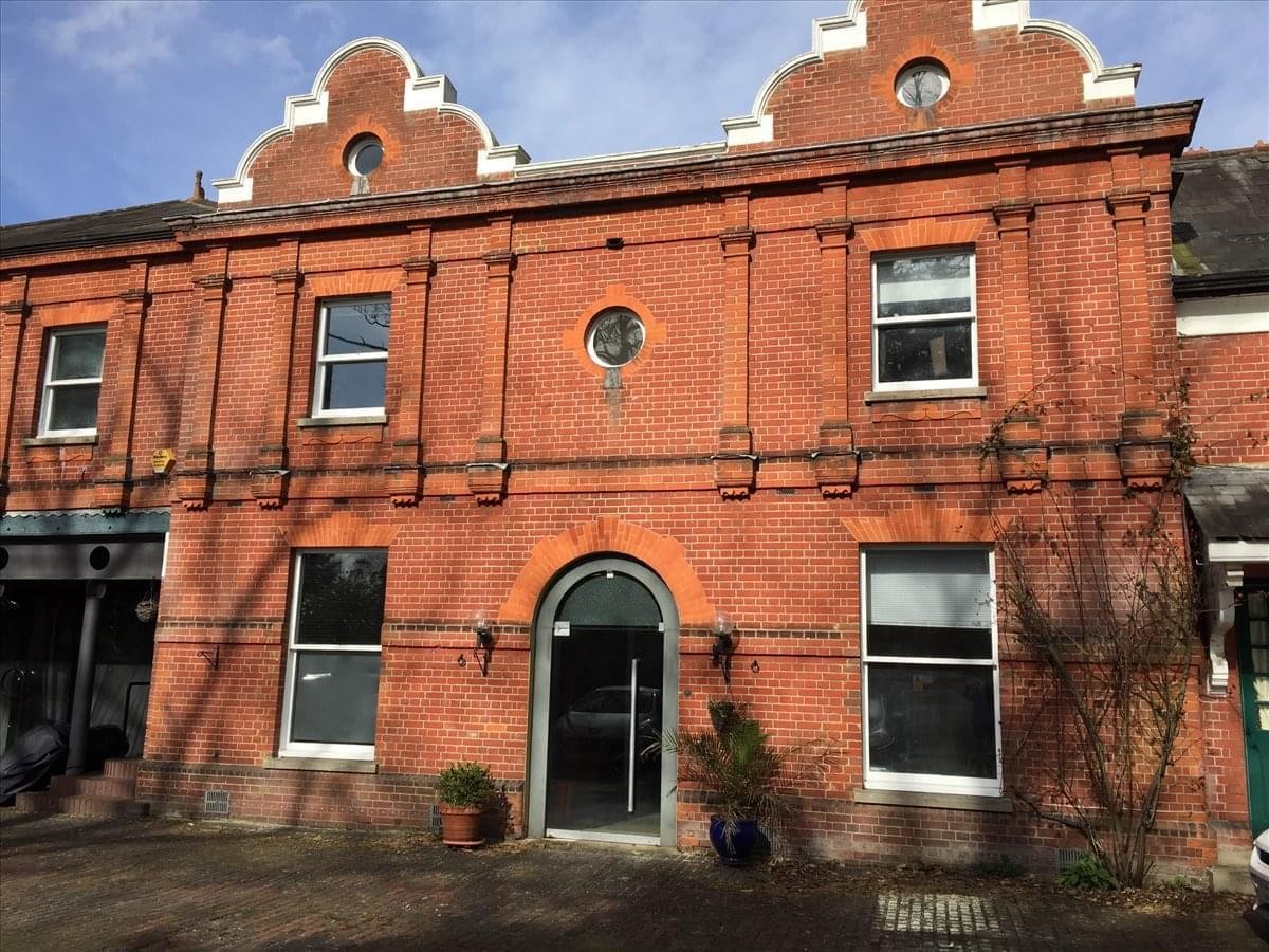 Grand red brick exterior of Iver Grove, Wood Lane with distinctive gabled roofline and arched entrance.