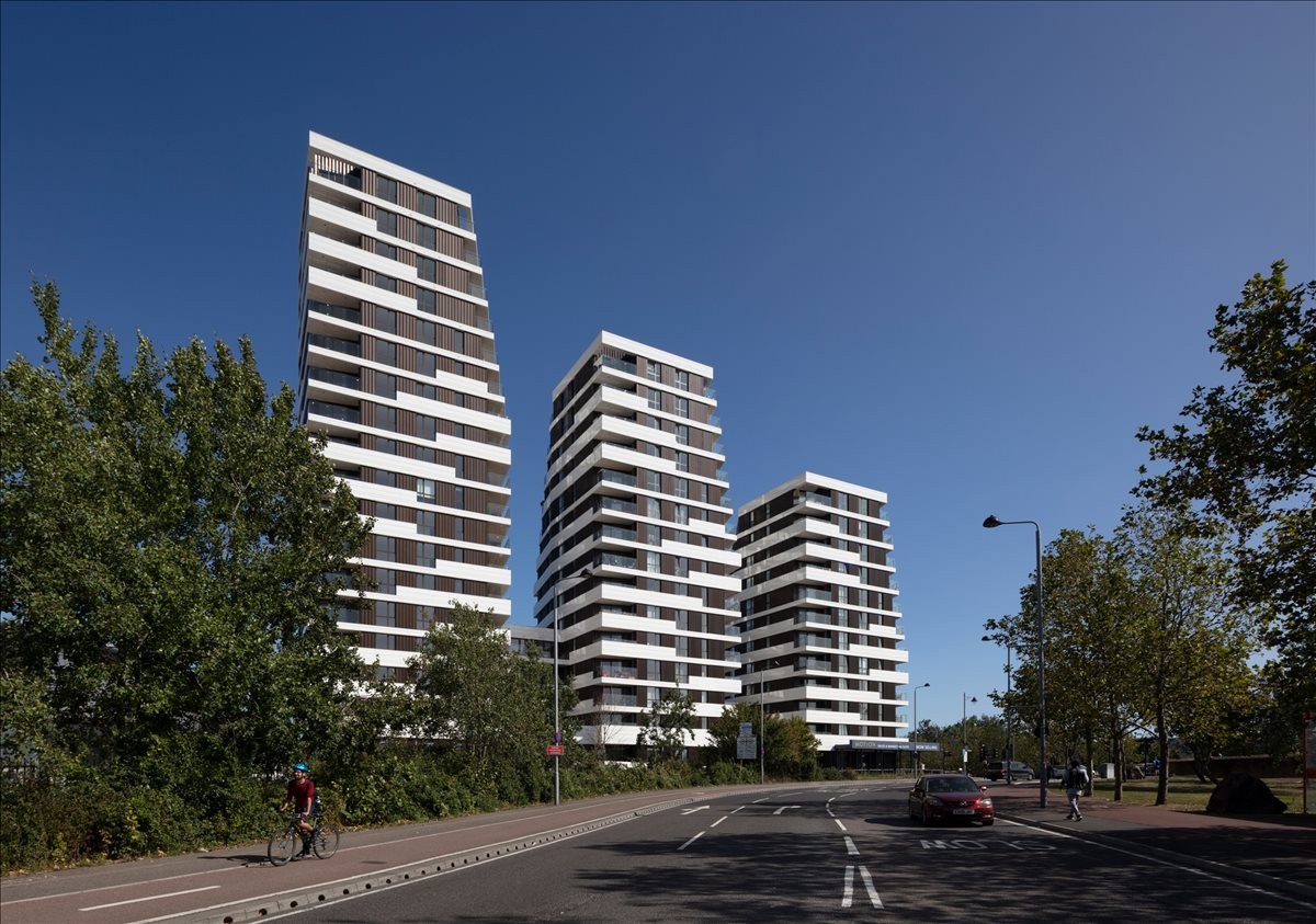 Exterior view of the modern, tiered white and black residential towers of Lea Bridge BSMNT Studios.