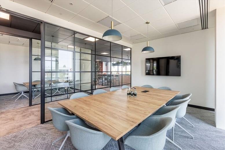 Spacious boardroom with a large wooden table and blue chairs at No 2 The Future Works, Slough.