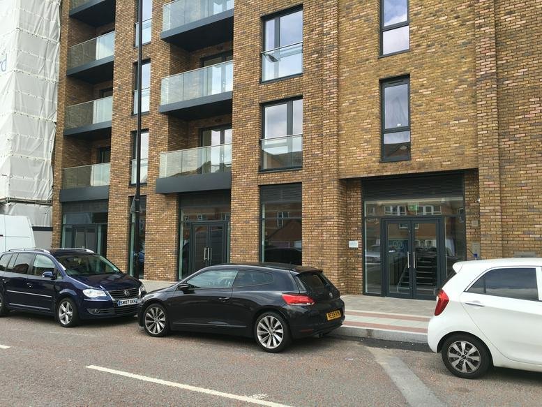 Exterior facade of the modern brick Quinton Court, Plough Way building with large windows.