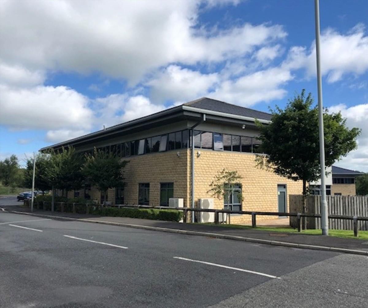 Exterior view of the brick-and-glass Vantage Court at Riverside Way under a blue sky.