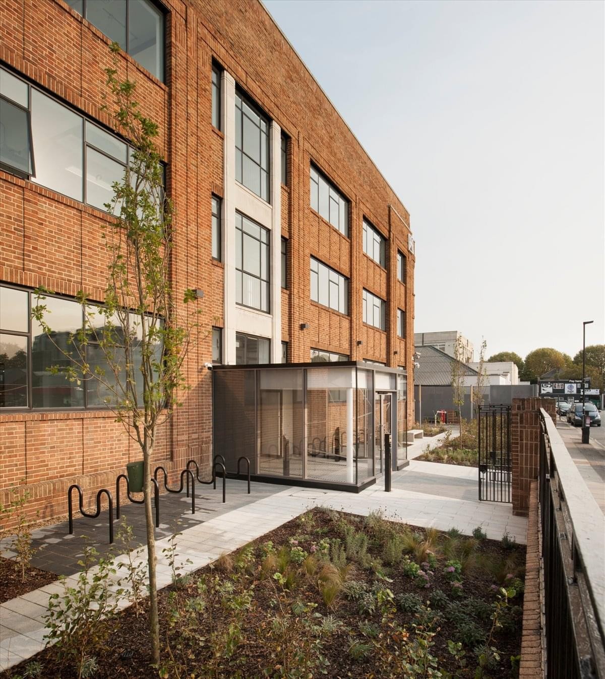 Exterior view of the red brick facade and modern glass entrance at Power Studios, 114 Power Road.