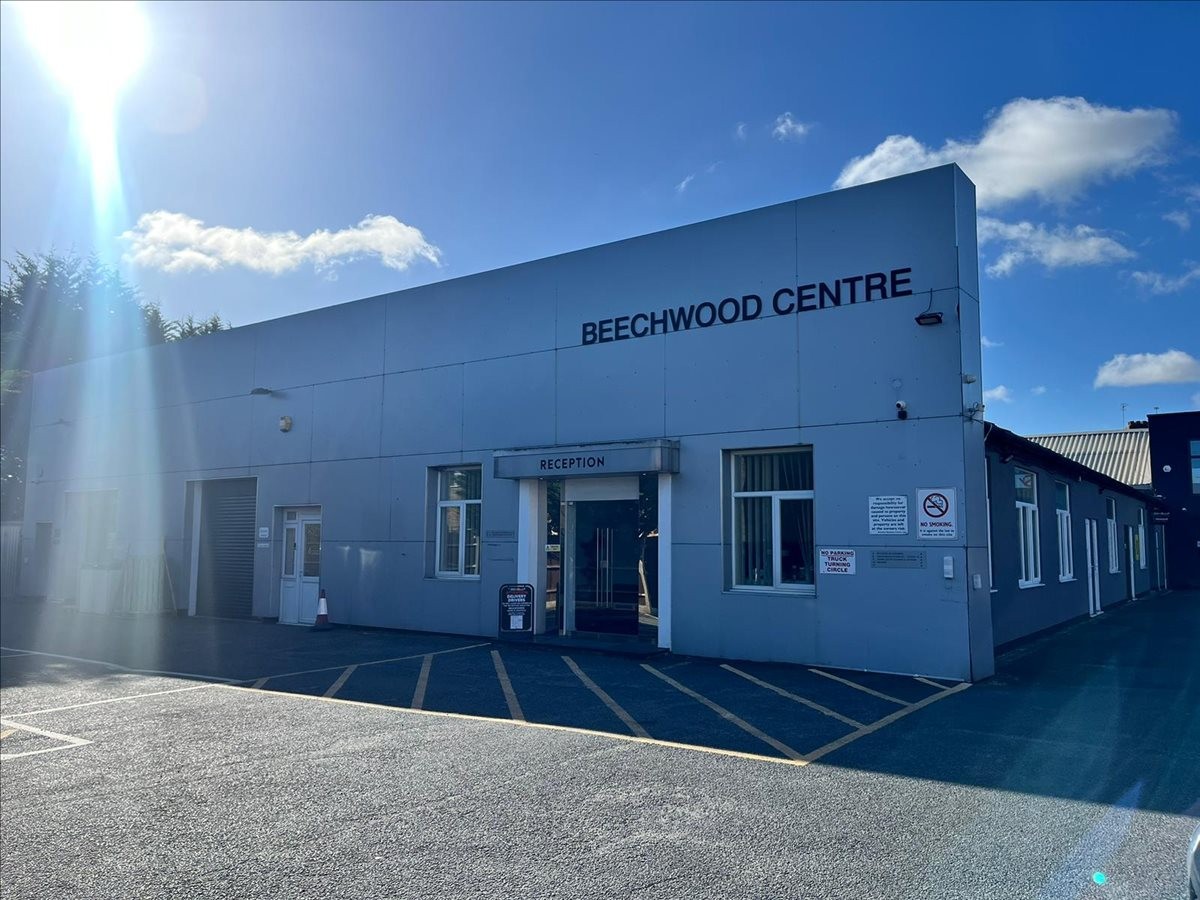 Exterior view of the light blue facade at The Beechwood Centre with parking area.