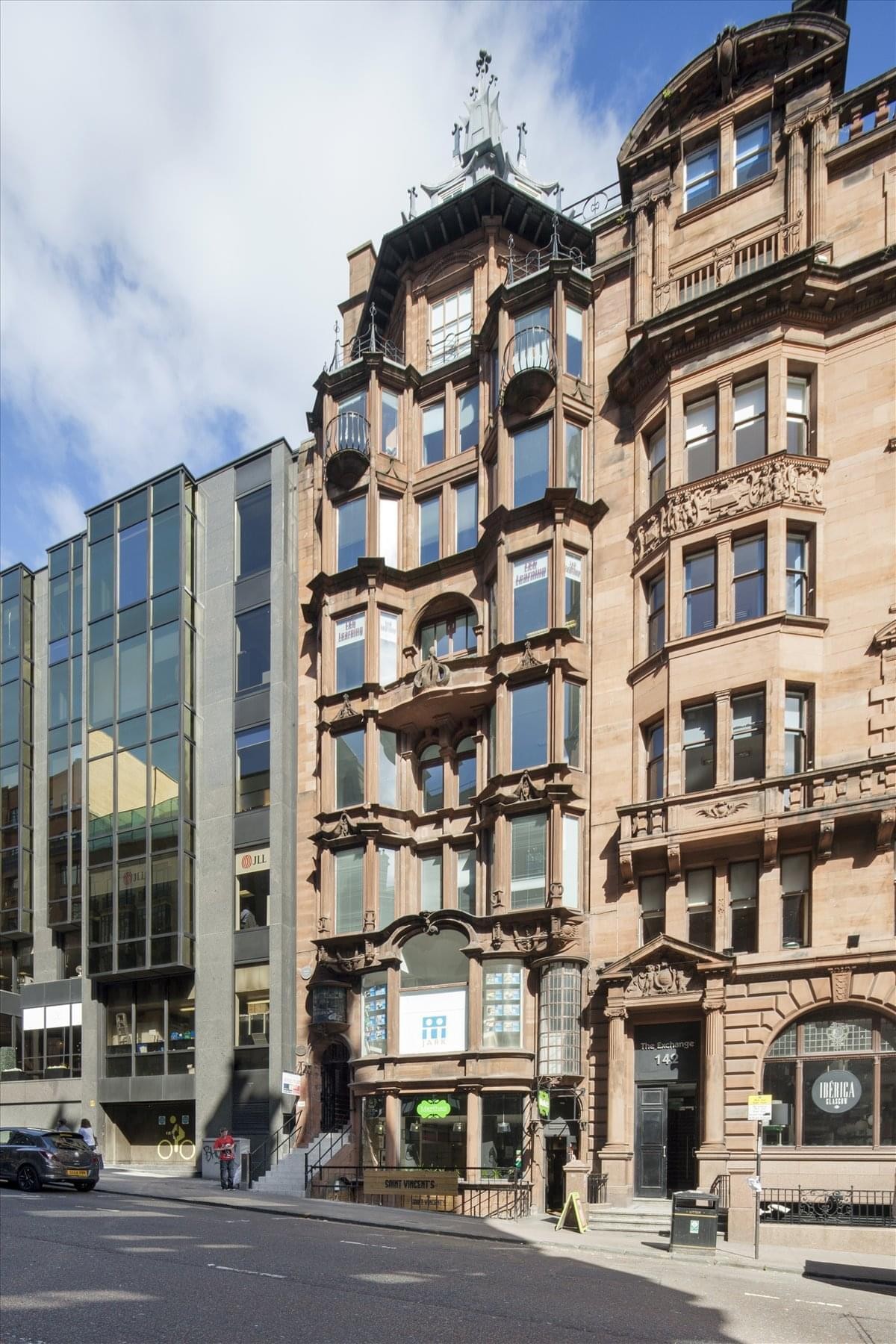 The ornate Art Nouveau sandstone facade of The Hatrack building in Glasgow featuring vertical bay windows.