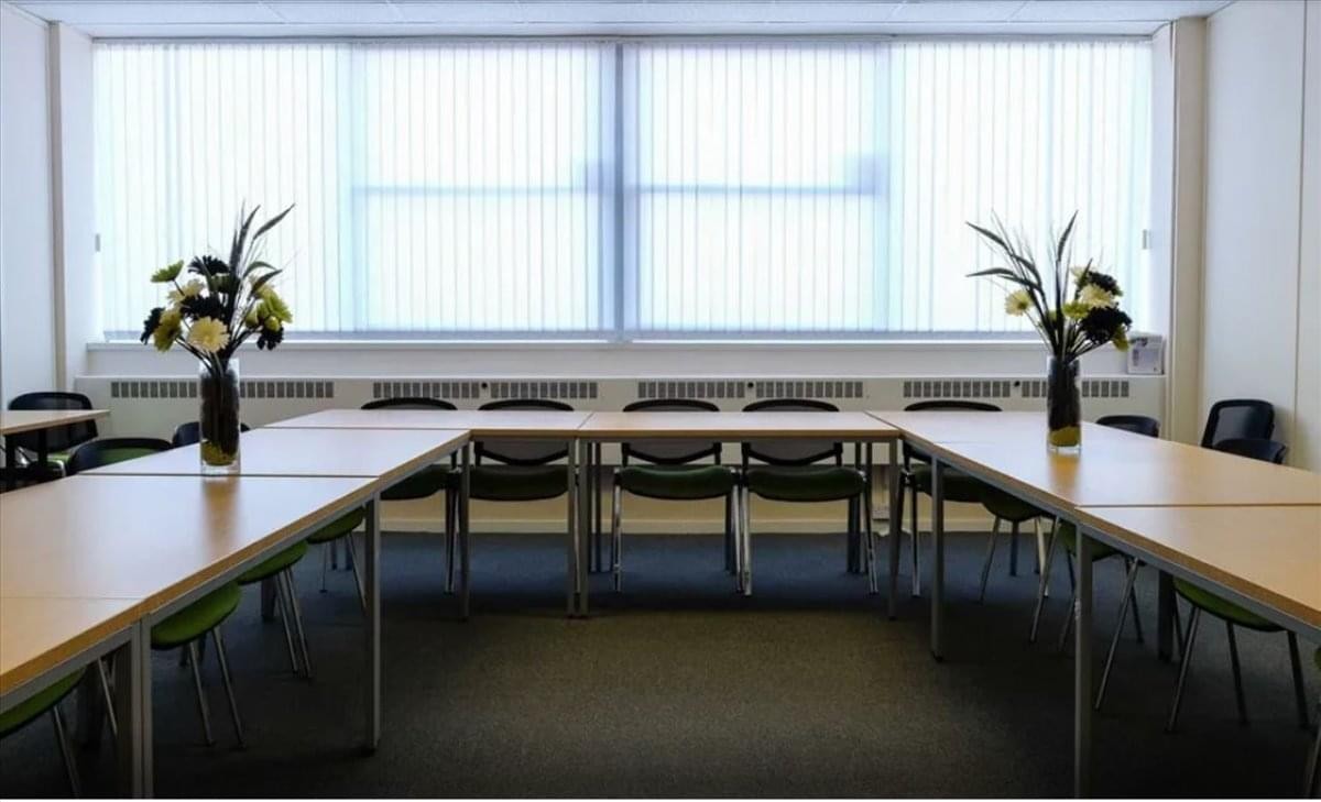 Meeting room at Toll Point Industrial Estate, Lichfield Road with U-shaped tables, chairs, and potted flowers.