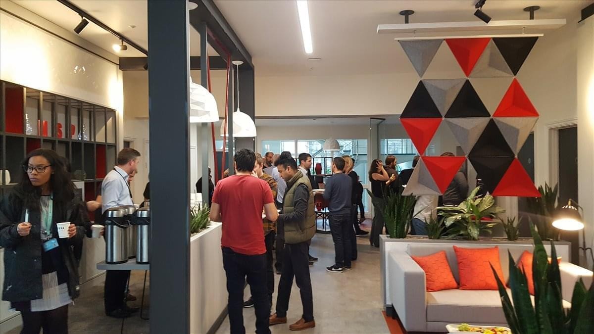 Spacious communal lounge at Williams House, Lloyd Street North, featuring a geometric wall hanging and people socializing.